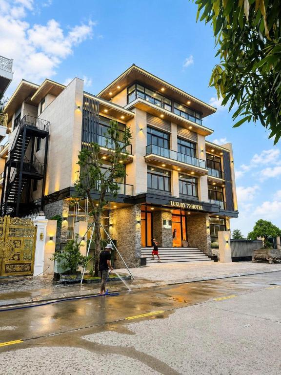 a man is standing in front of a building at Luxury 79 Hotel Hải Phòng in Hai Phong