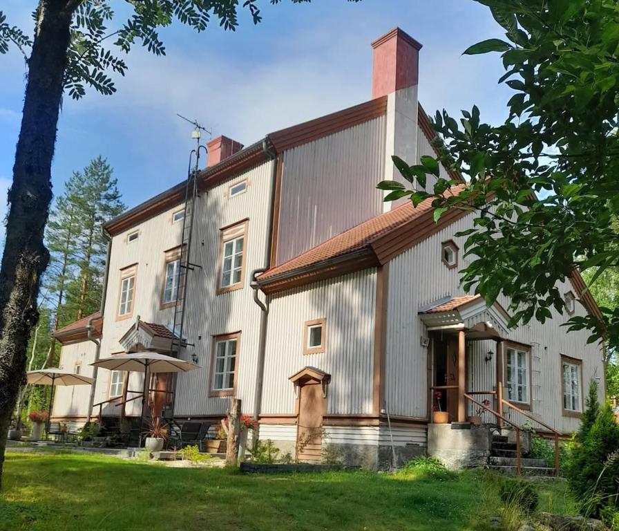 ein großes weißes Gebäude mit einem Mansarddach in der Unterkunft Maininki in Sulkava