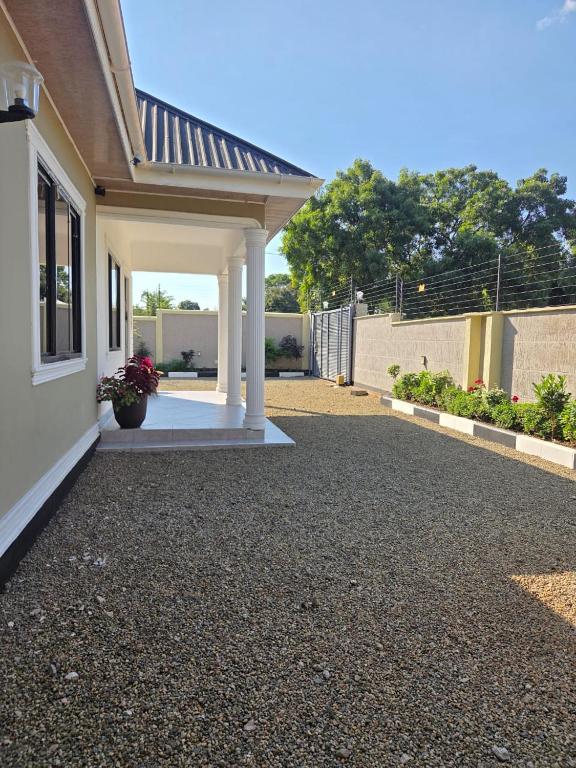 a house with a gravel driveway in front of it at Boma Retreat in Boma la Ngombe