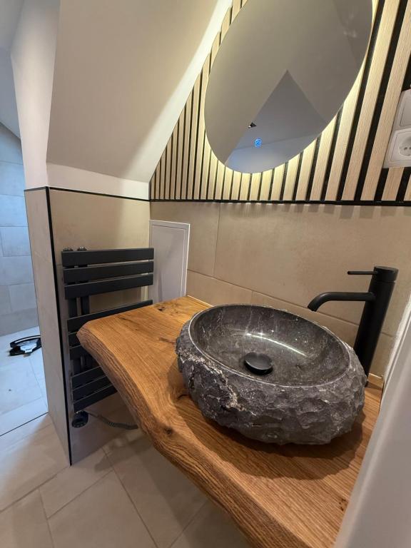 a bathroom with a stone sink on a wooden table at EJ Apartments in Gartow