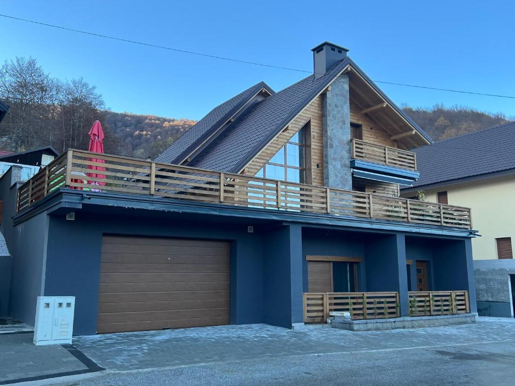 a house with a garage and a deck on top at Villa Lake House in Mavrovo