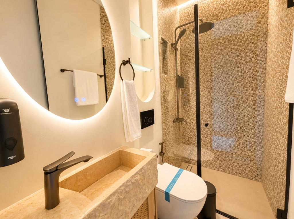 a bathroom with a sink and a shower at Inanna Resort in Kifrayyā