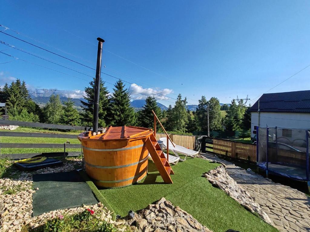 a large wooden barrel sitting on the grass at Casa Sofisa in Fundata