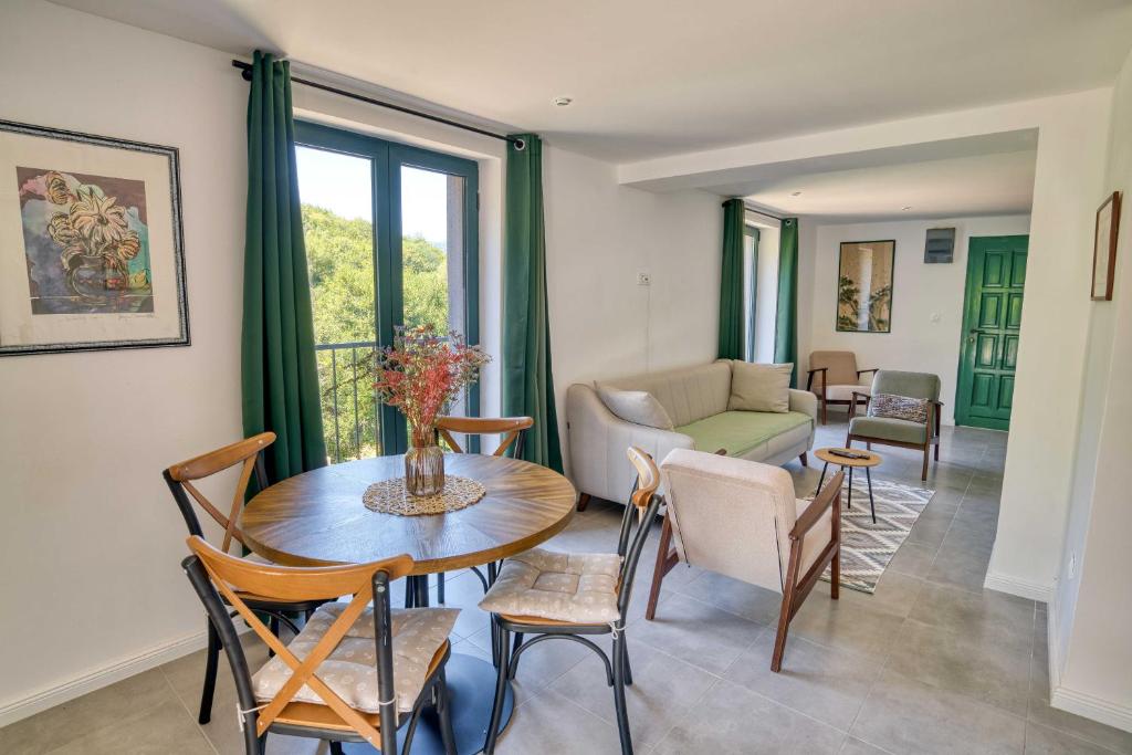 a living room with a table and chairs and a couch at Calm apartment in Lepetane in Tivat