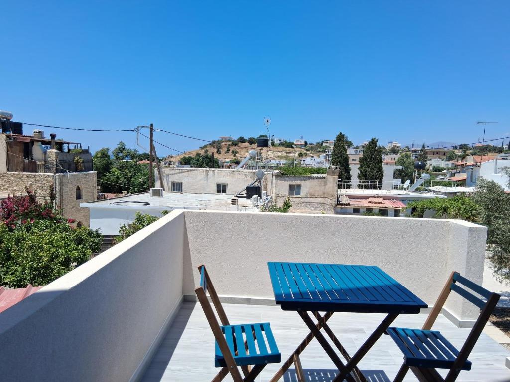 a blue table and two chairs on a balcony at katina 26 in Pitsidia