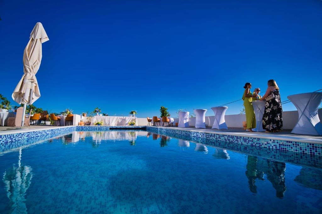 a group of people standing next to a swimming pool at Vila Slavonika in Slavonski Brod