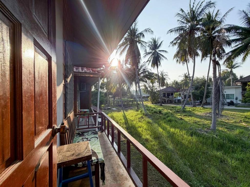 a balcony of a house with a view of a yard at Neziha's Homes in Thong Sala