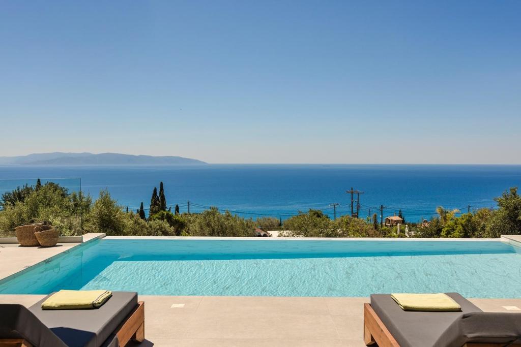 a swimming pool with a view of the ocean at Ionian Dreaming in Lourdata