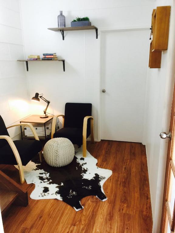 a living room with a table and chairs and a rug at Cottage on Cork - Muddy Cottage in Winton
