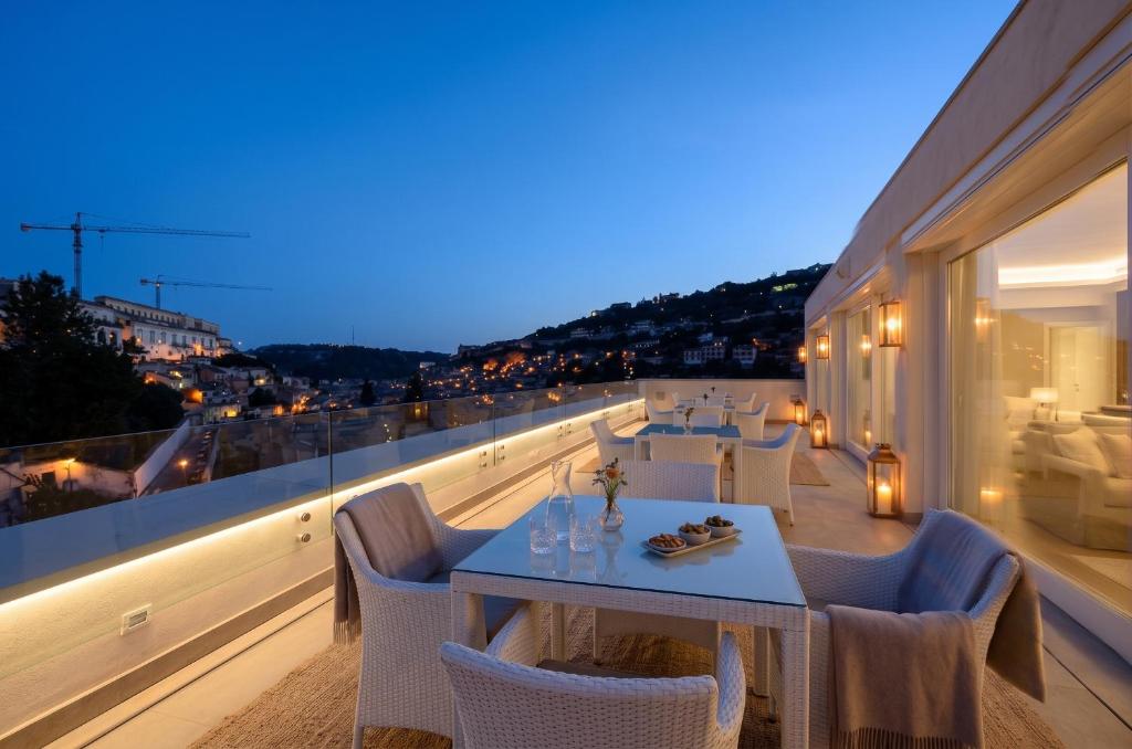 a restaurant with a table and chairs on a balcony at San Giorgio Modica Hotel in Modica
