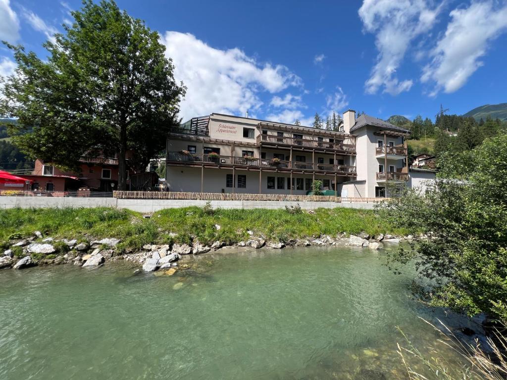 a building with a river in front of it at Schlossalm Appartement in Bad Hofgastein