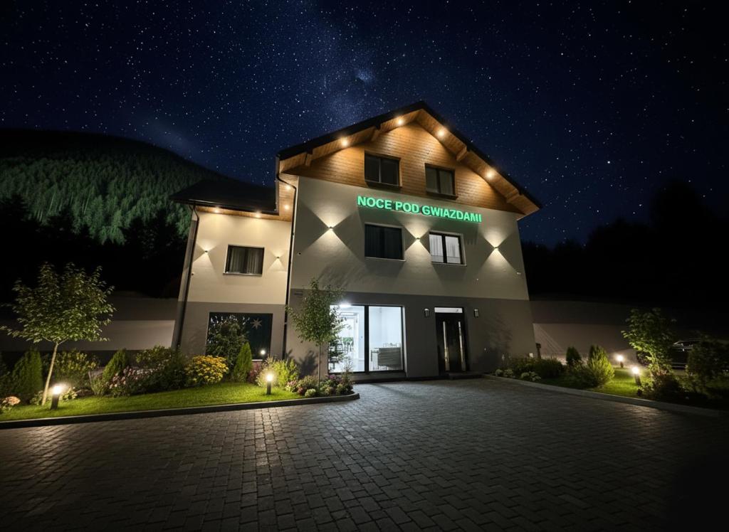 a building with a nice dog courtyard at night at Noce pod Gwiazdami in Sidzina