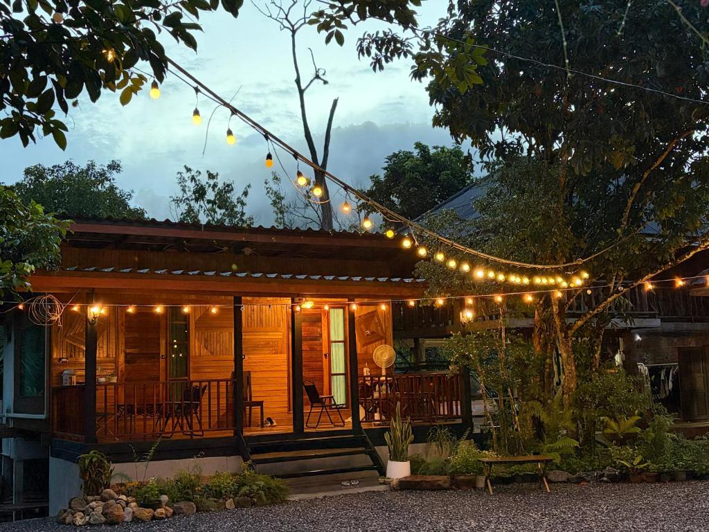 a house with a string of lights on it at บ้านไม้ชายแดนกาแฟสดแอนด์โฮมสเตย์ in Ban Ba Nam Ron