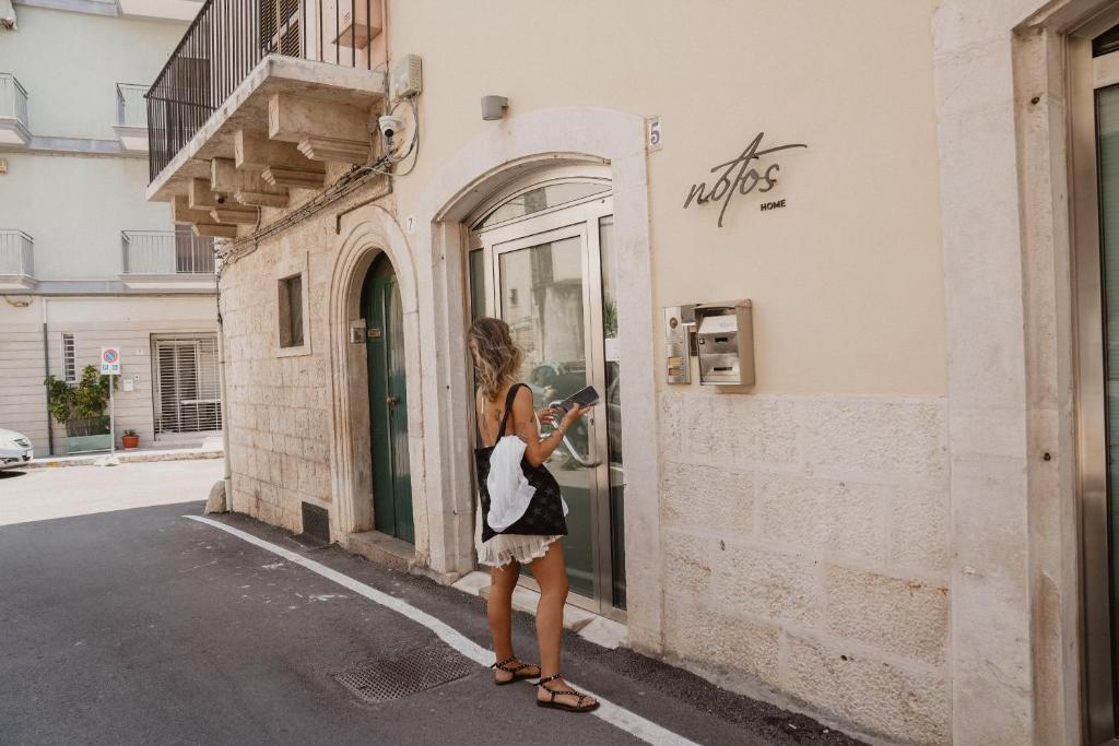 a woman taking a picture of a building at Notos Home in Bitonto