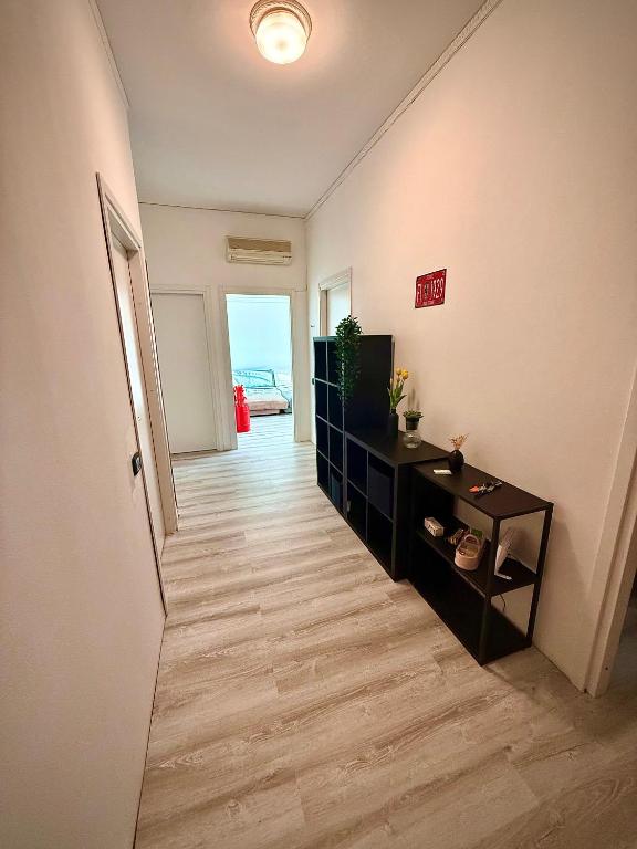 a room with a hallway with a television and a table at We4 apartment Maranello in Maranello