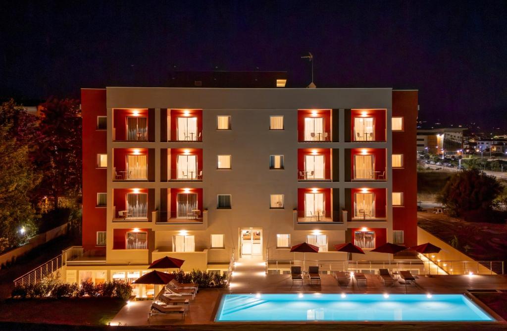 a hotel with a swimming pool in front of it at PALAZZO RUBINO Aparthotel in Olbia