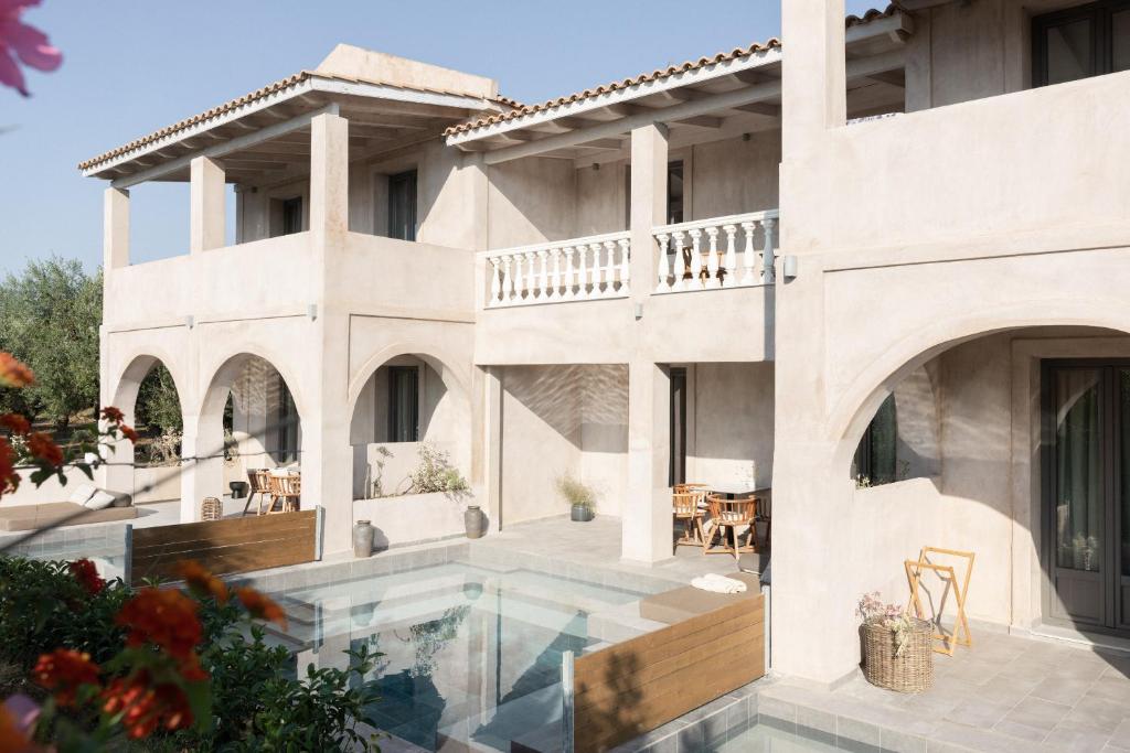 a white house with a swimming pool and a patio at Casa di Pierro in Lithakia