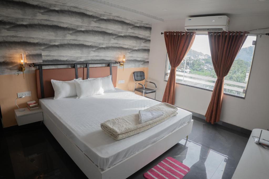 a bedroom with a large white bed and a window at Divine View- Boutique Stay in Guwahati