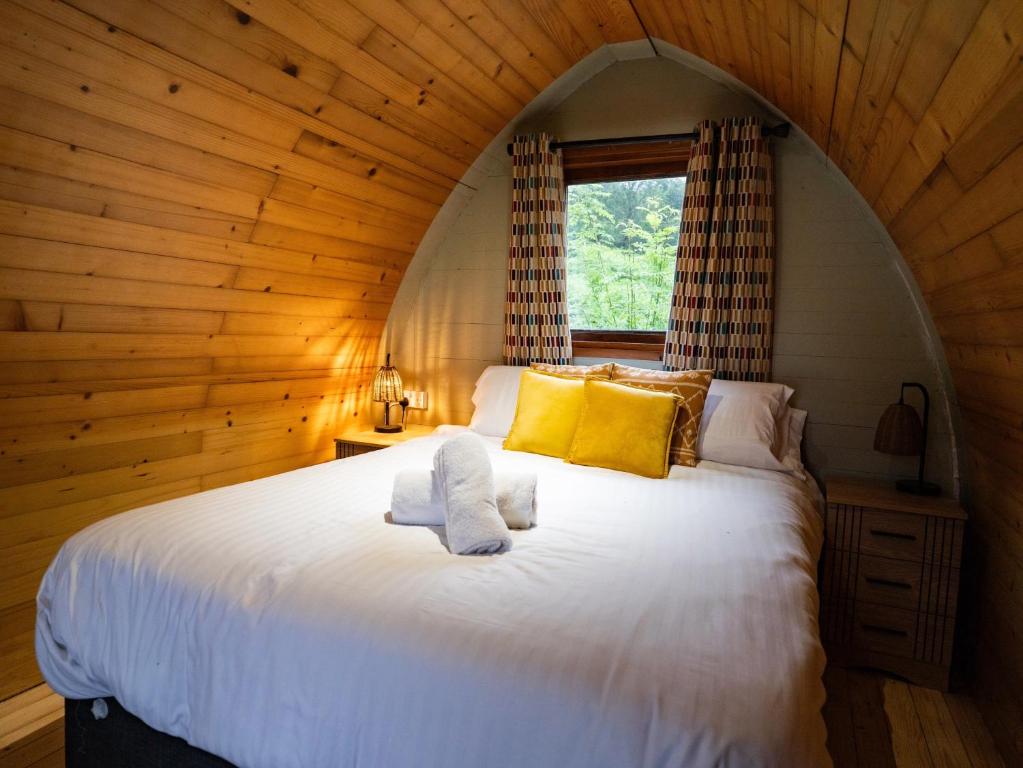 a bedroom with a large white bed with a window at Revive Wellness Pods in Rostrevor