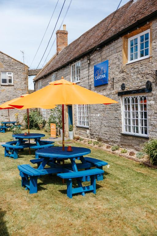 a group of picnic tables with an umbrella at Northover Manor Hotel in Ilchester