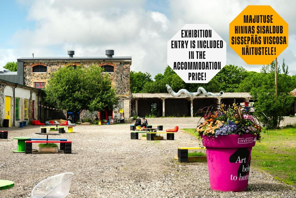 a park with a large pink pot of flowers and signs at Viscosa Hotell in Kõrgessaare