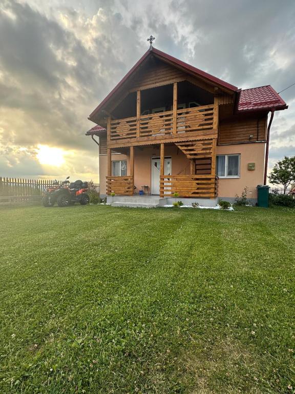 a wooden house in a field with a fence at Ela’s retreat in Dealu Mare