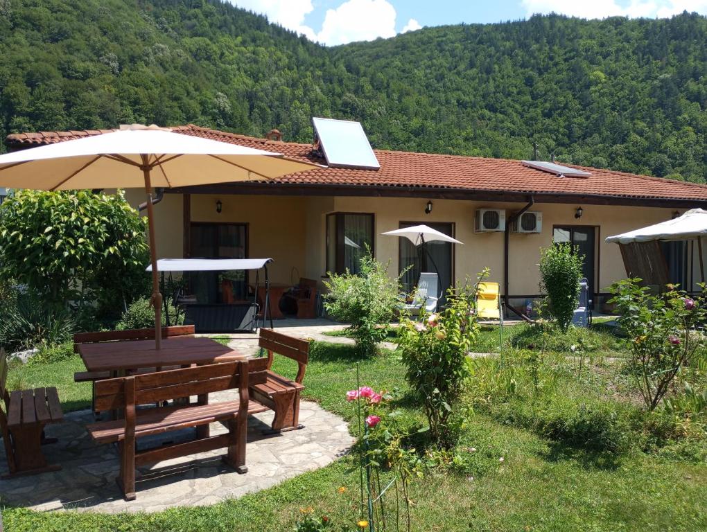 a house with a picnic table and an umbrella at КръчмЪ При Байката in Ribarica