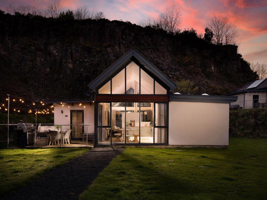 a house with a large window on a lawn at Summerset Lodge in Bamburgh