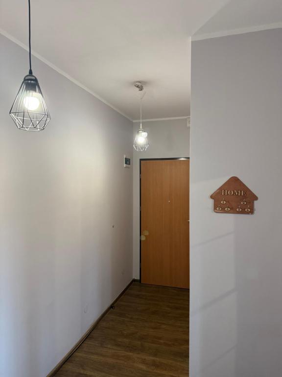an empty room with a door and two lights at Apartament Piętrowy 138m2 in Gniezno
