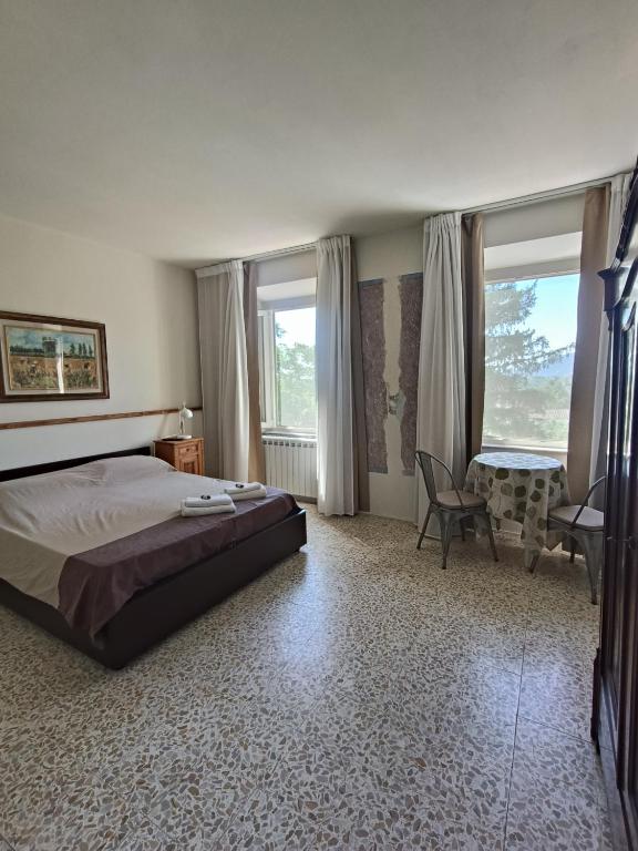 a bedroom with a bed and a desk and windows at Domus Mazzoni in Capannori