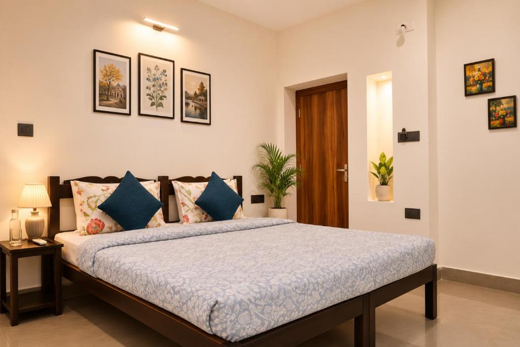 a bedroom with a large bed with blue pillows at Hotel Atithya in Udaipur