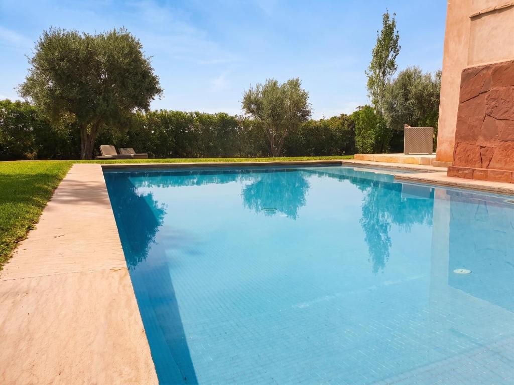a swimming pool with blue water in a yard at Elegant Villa in Marrakech with a Private Pool. in Douar bel Rhanodour