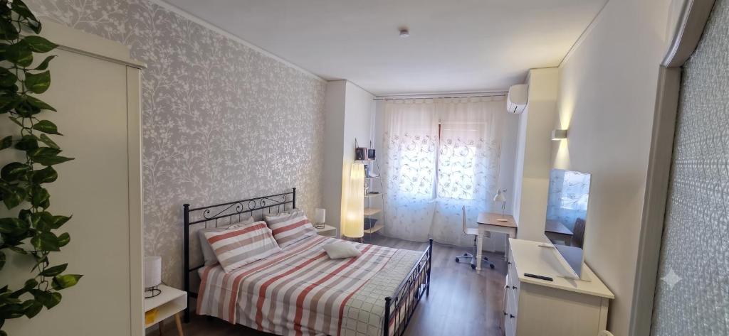 a bedroom with a bed and a desk and a window at Alloggio per uso Turistico Capone Alessia - A DUE PASSI DAL CENTRO in Viterbo