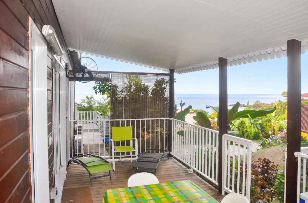a balcony with a view of the ocean at Bungalow confortable avec vue mer à Bouillante in Bouillante