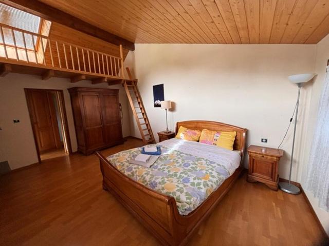 a bedroom with a bed and a wooden ceiling at Malgré tout 2 in Salvan