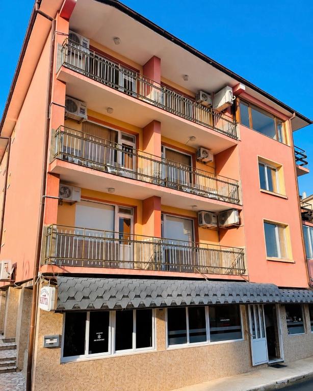 an apartment building with balconies on a street at KITA - Rooms with Sea View in Sveti Vlas