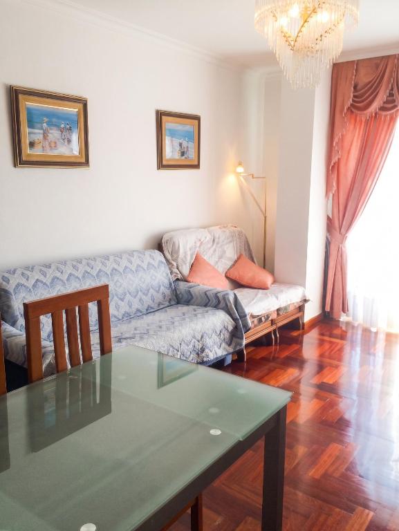 a living room with a couch and a table at Charming Apartment in El Grove, Sea View in O Grove