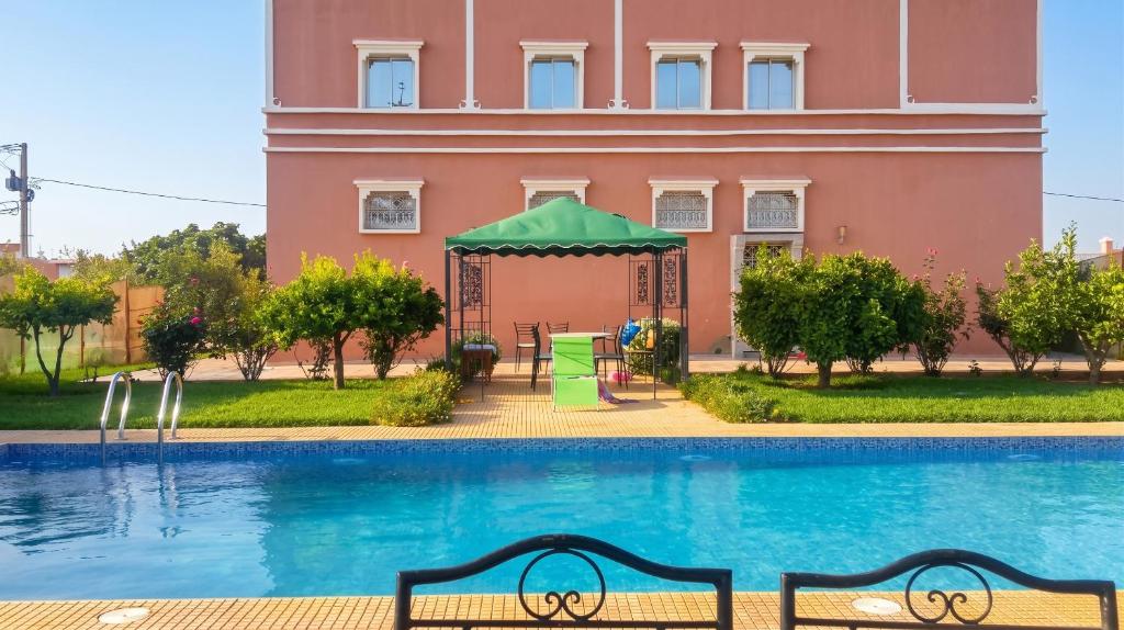 a pool in front of a pink building at Charming Villa in Tou Ganaou with Private Pool in Ti nʼ Saïd