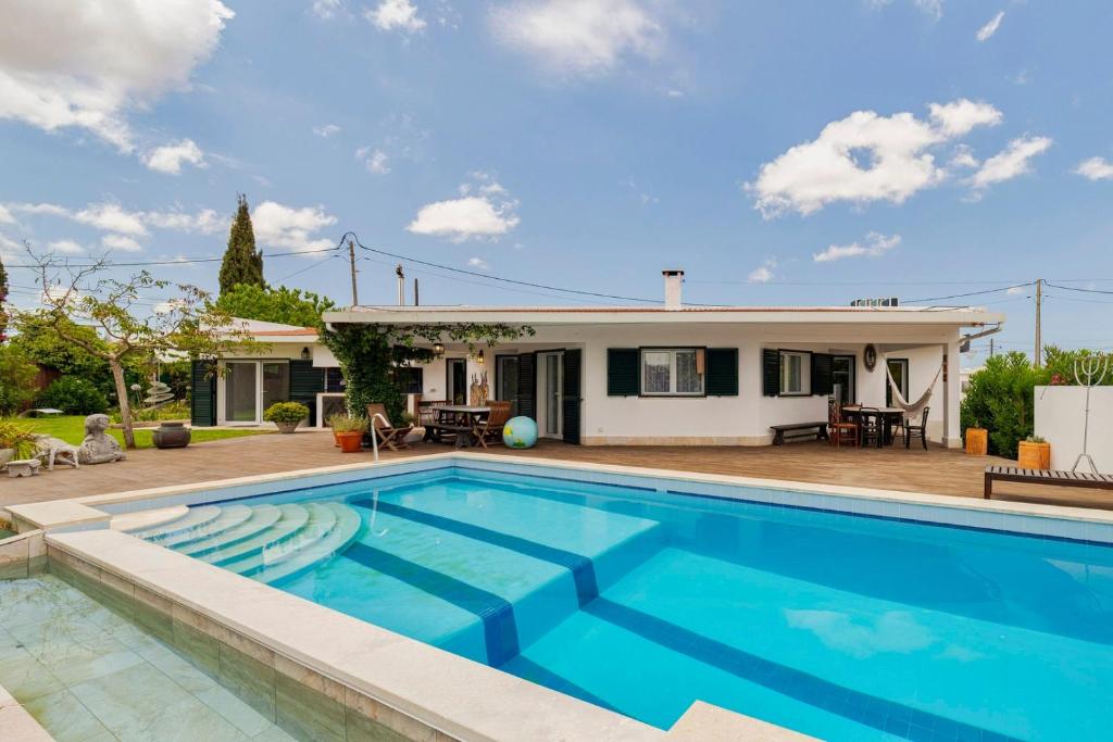 a swimming pool in front of a house at Quinta da Amora in Quinta do Anjo