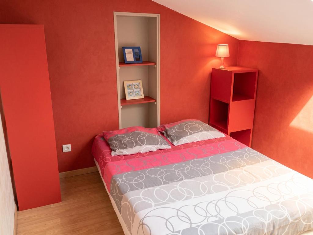 a bedroom with a bed in a red wall at Appartement charmant à Roanne, terrasse in Roanne