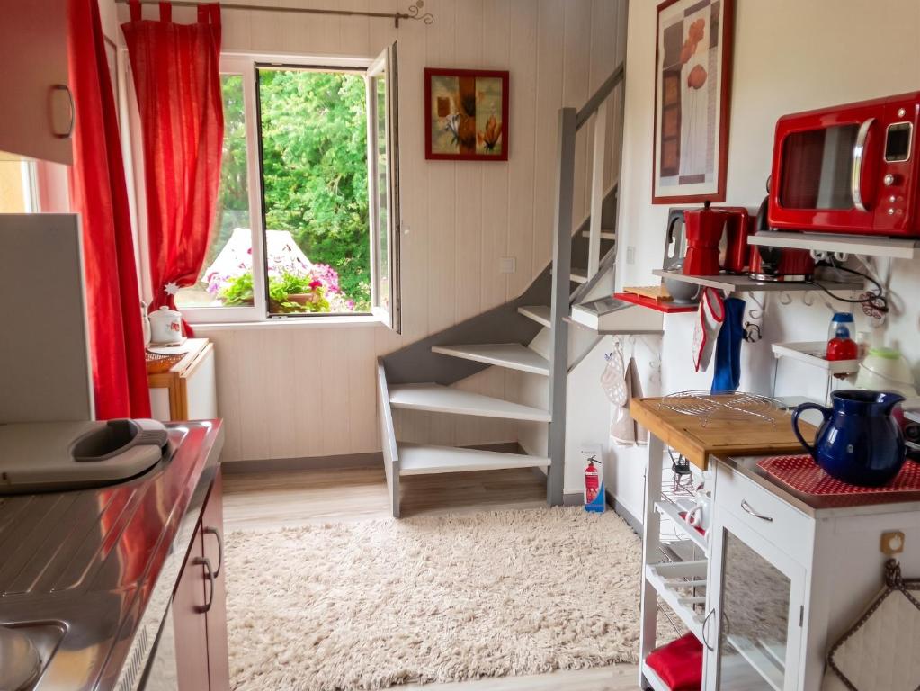 a kitchen with a spiral staircase and a window at Appartement cosy aux Authieux Papion 15 m² avec jardin privatif in Les Authieux-Papion