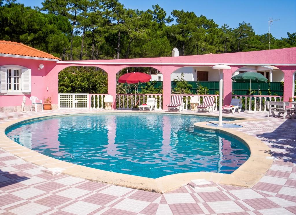 a swimming pool in front of a pink house at Charming Apartment in Sintra with Pool in Sintra