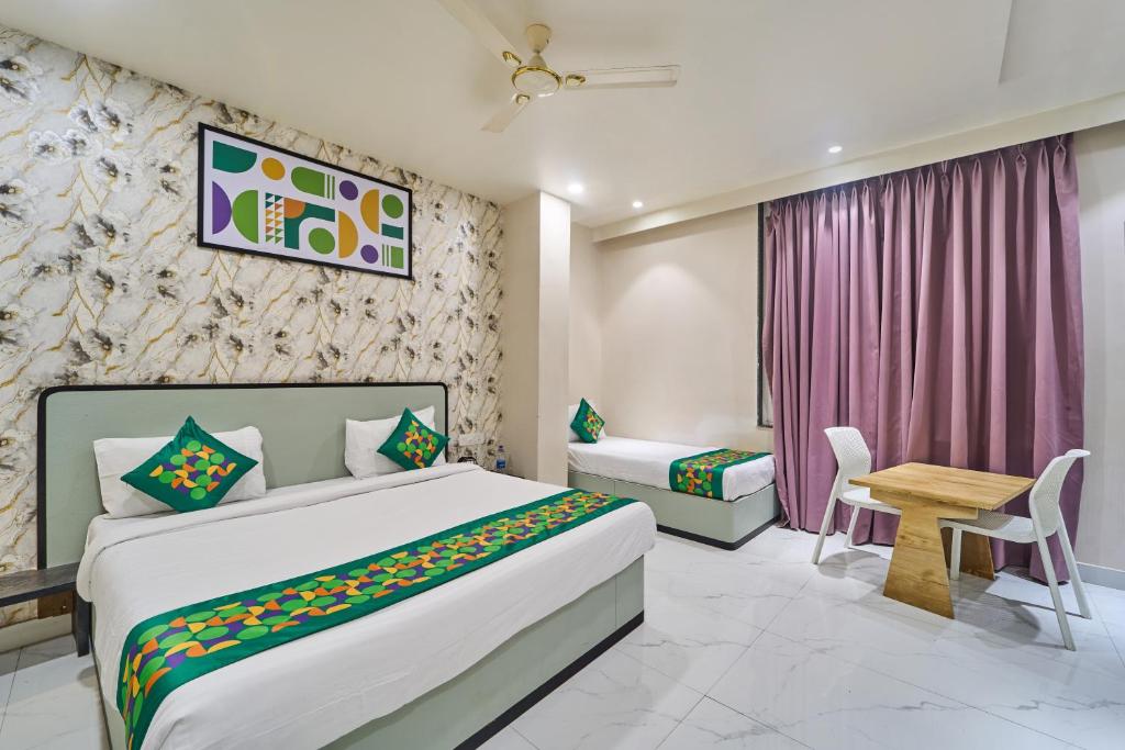 a hotel room with a bed and a table and a desk at Treebo Park View Villa in Jodhpur