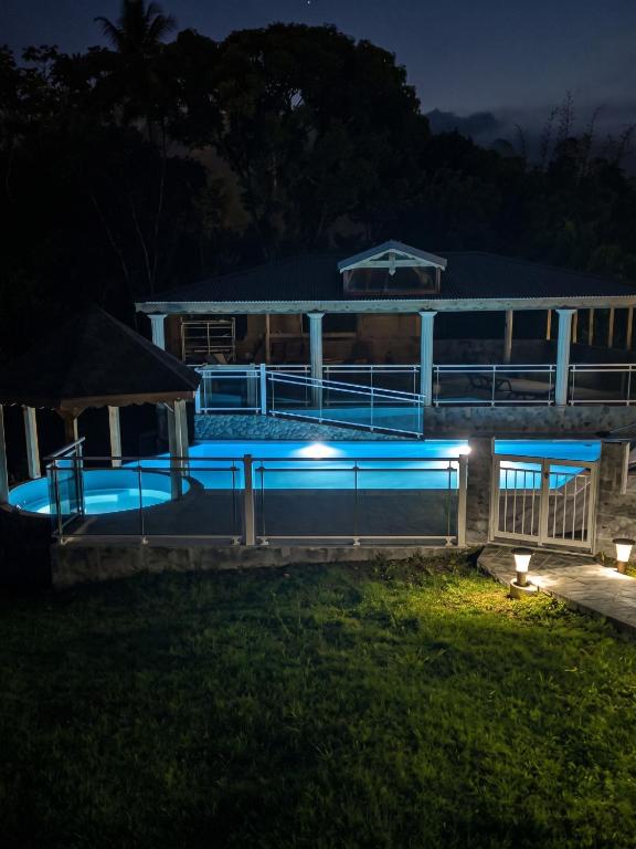 a house with a swimming pool at night at Appartement charmant à Lamentin avec piscine partagée in Lamentin