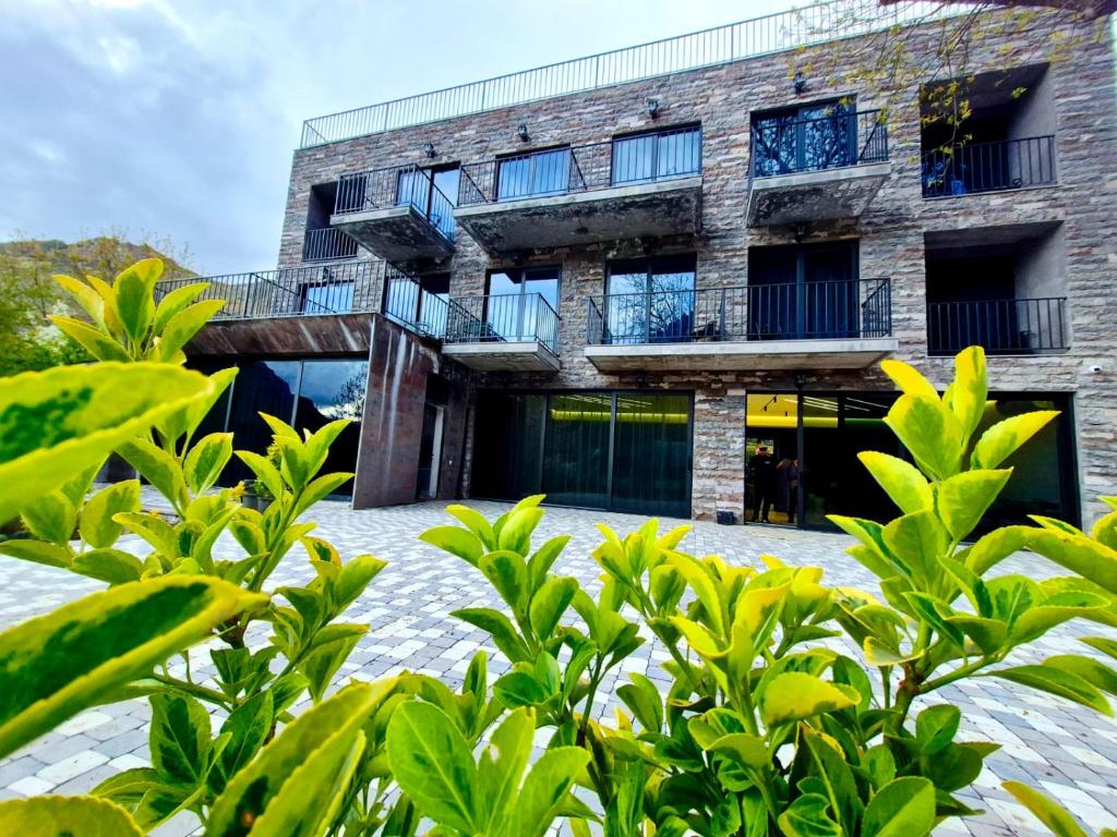 a brick building with balconies and trees in front of it at Musa Hotel in Yeghegis