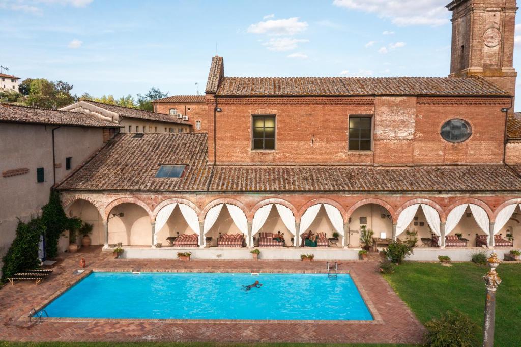 an external view of a building with a swimming pool at Hotel Certosa Di Maggiano in Siena