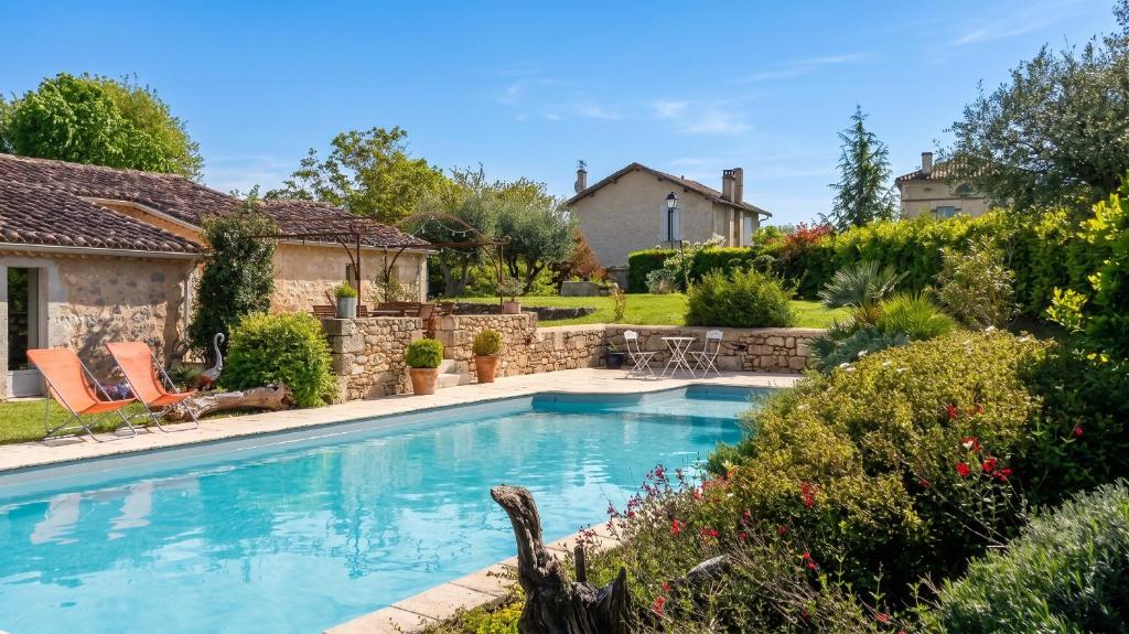 a swimming pool in a yard with a house at Appartement charmant à Castéra-Lectourois avec piscine partagée in Castéra-Lectourois