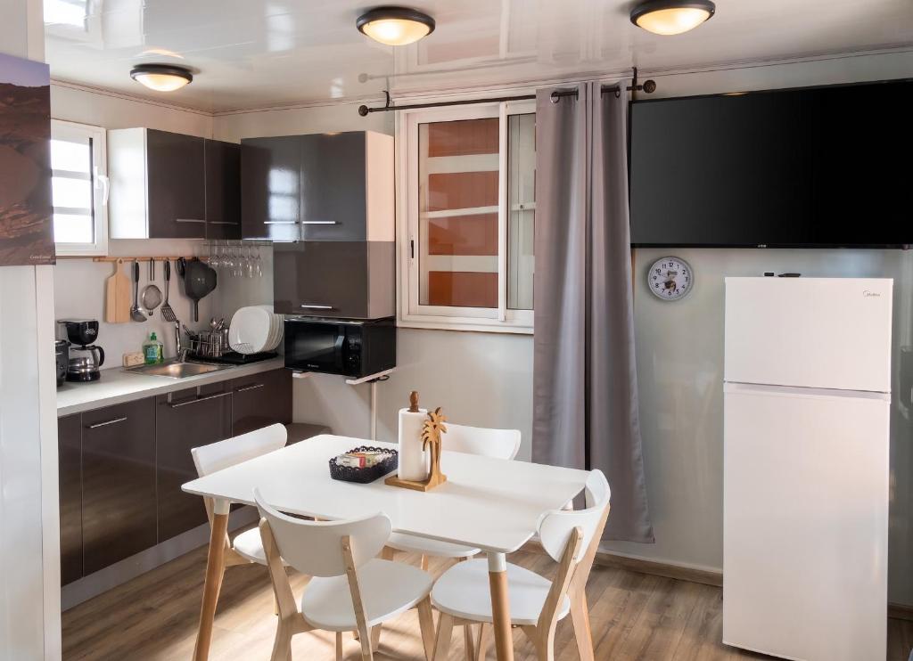 a kitchen with a white table and white chairs at Studio confortable à Sainte-Suzanne, 20 m², balcon in Sainte-Suzanne