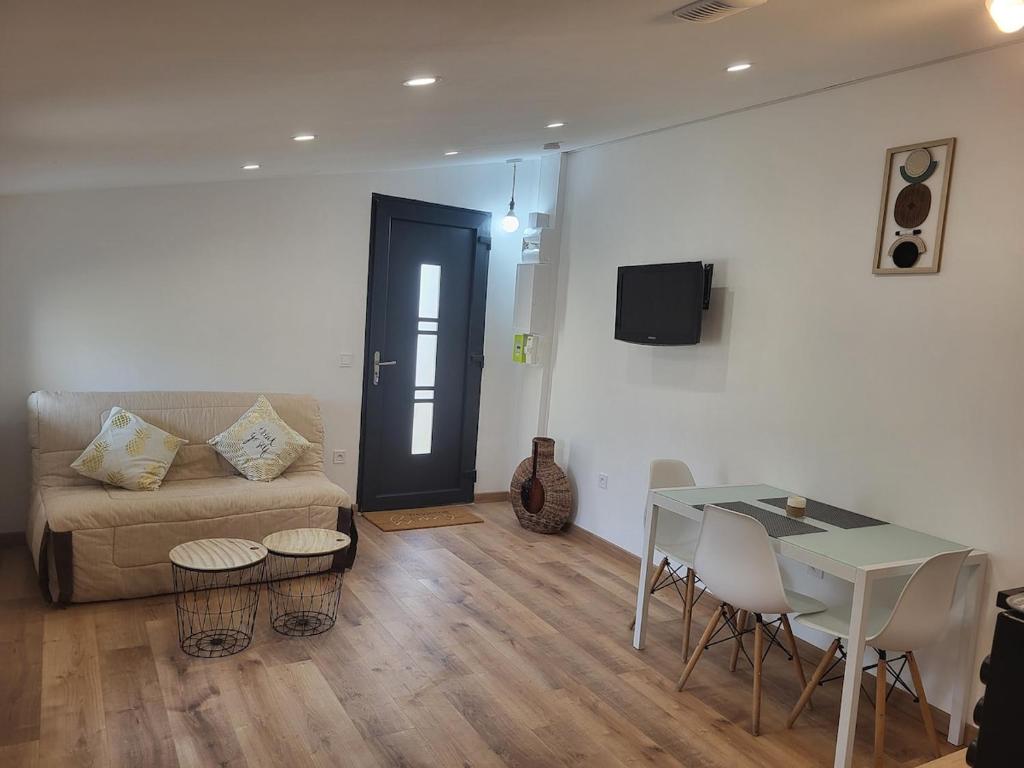 a living room with a couch and a table at Studio chic meublé et lumineux in Chauray