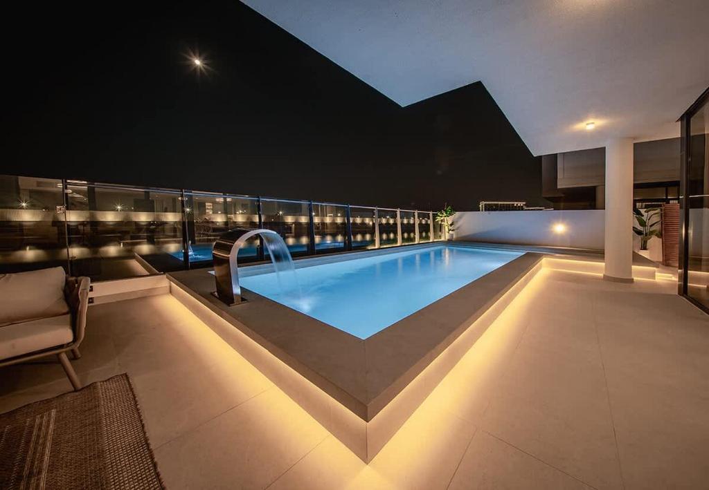 a swimming pool on top of a building at night at Blausee Beachfront Villa with Private Pool in Al Ḩamrīyah